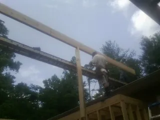 Carpenter setting a ridge beam over a new addition frame — Ice Dam Removal by Roofing Brothers in Fogelsville
