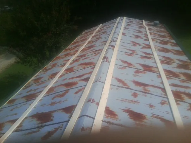 Rusted metal roof panels with new wood purlins before replacement — Storm Damage Roof Repair in Fogelsville by Roofing Brothers