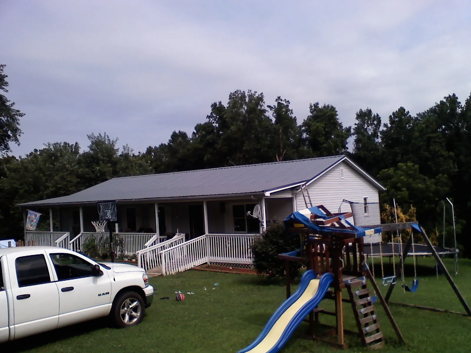 Dark metal roof on a country home with a full length front porch in Fogelsville