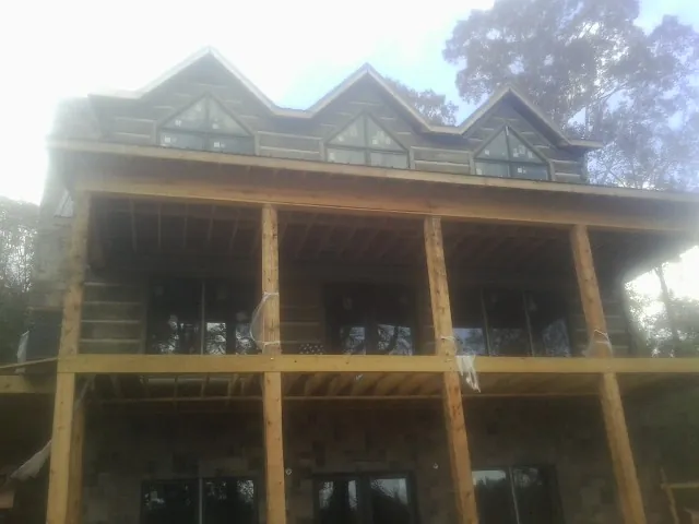 Dormers and porch framing on a large log home under construction — Roof Coating work by our crew in Fogelsville