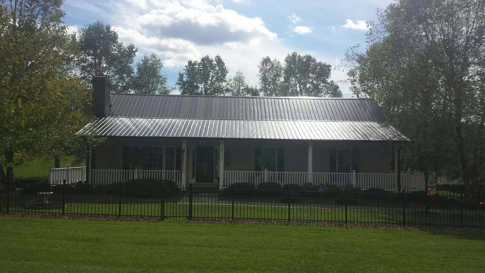 Gray metal roof on a brick ranch with a full width front porch — Gutter Guard Installation work by our crew in Fogelsville